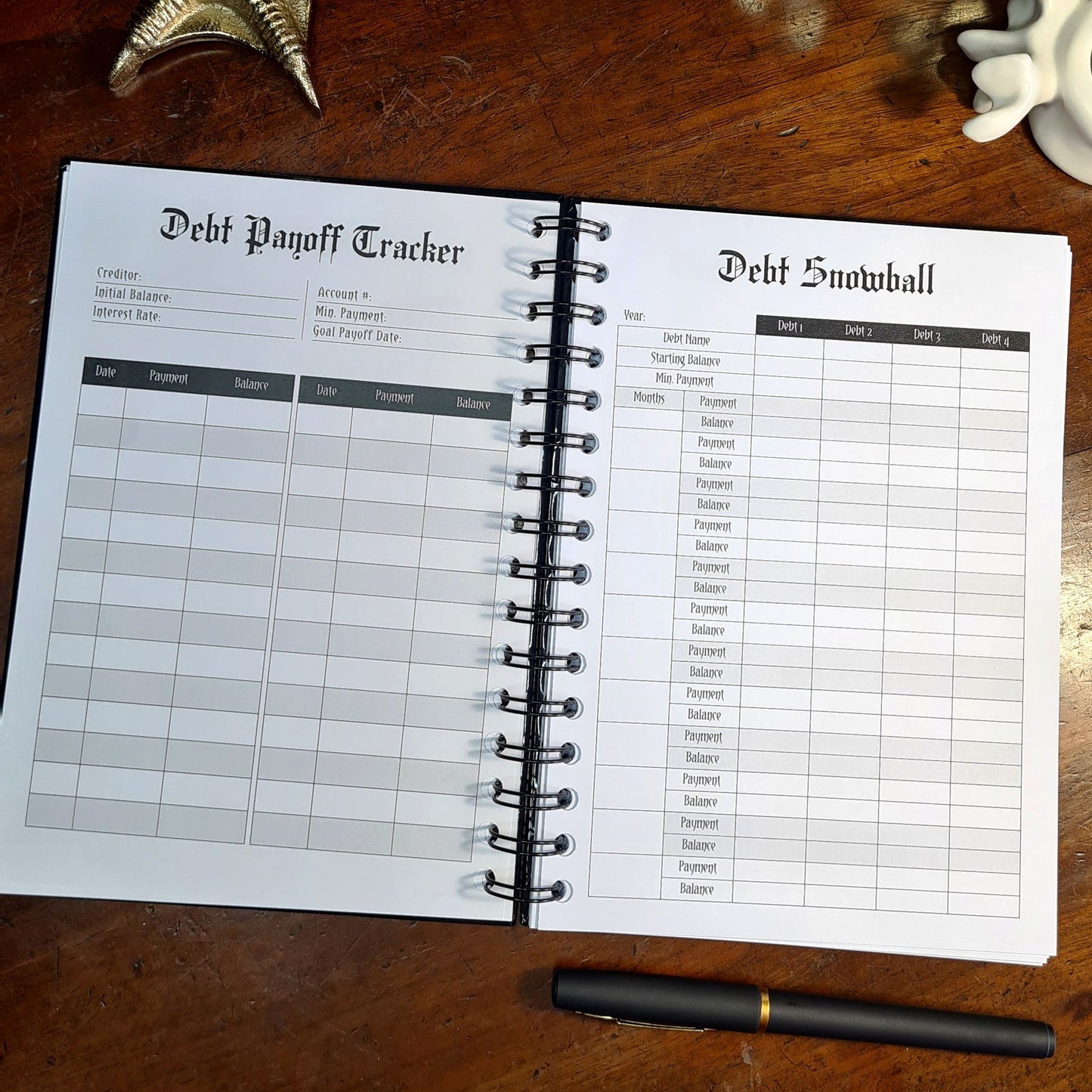 A two-page layout inside the Financial Planner by Gothic Office. The left page is a Debt Payoff Tracker and the right a a Debt Snowball table.