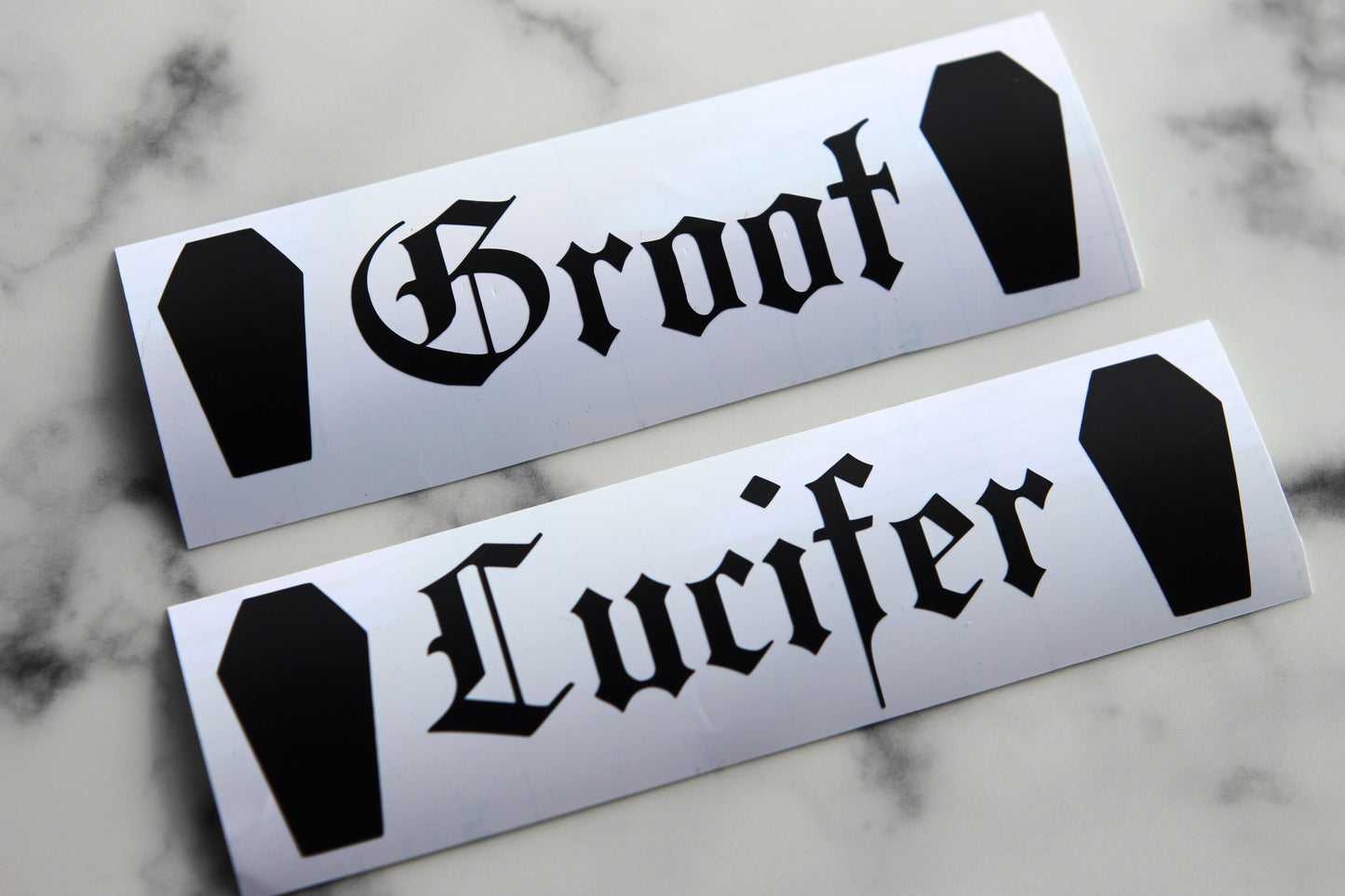 This is two personalised vinyls by Gothic office saying Groot and Lucifer with coffins either side.