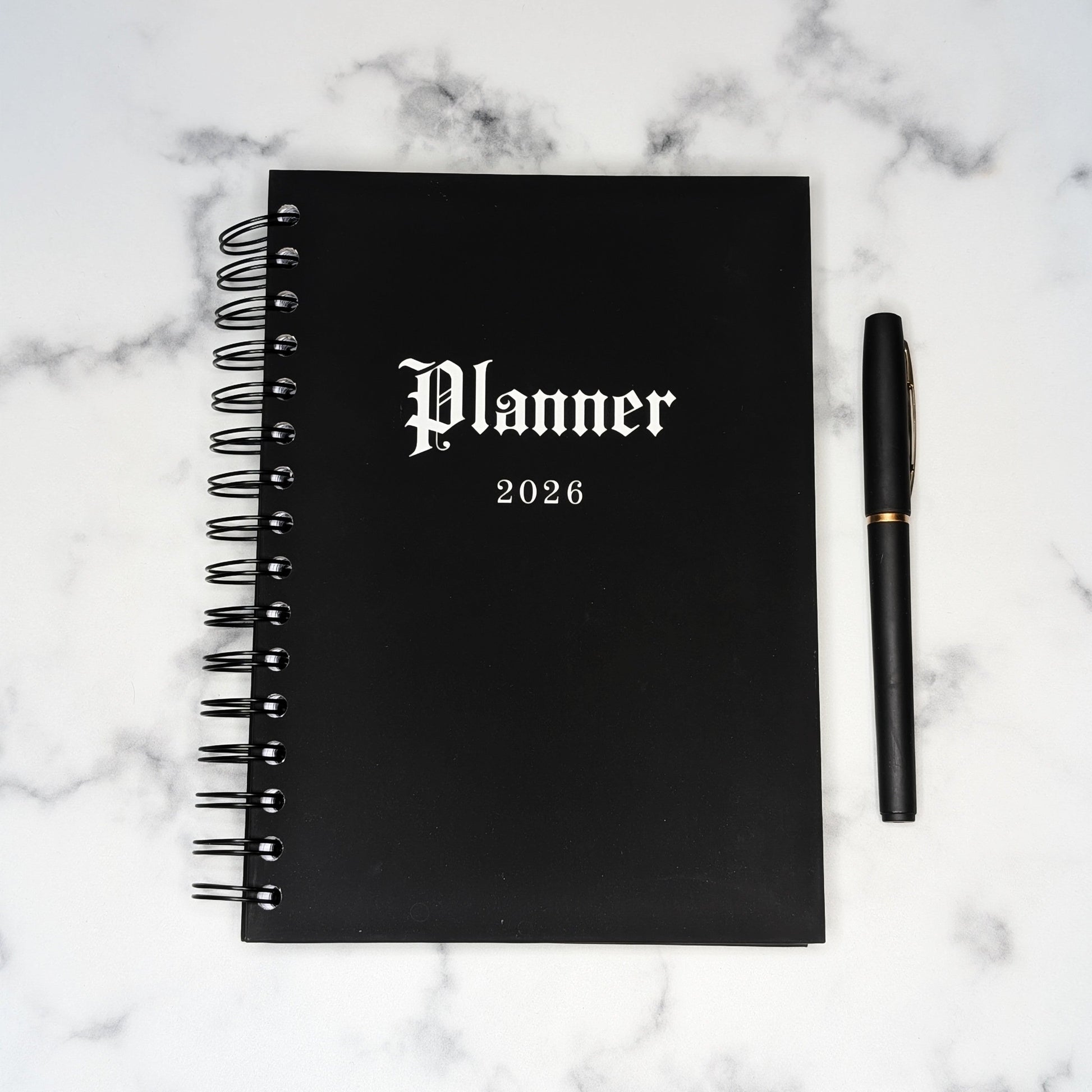The front of the Gothic Office 2026 Planner which is jet black with white gothic font saying the word Planner and 2026. 